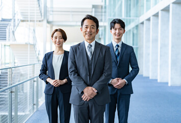 社内に立つ3人のビジネスマン