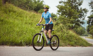 Obraz premium Mountain biking on summer forest trail