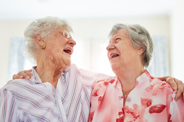 Friends, senior women and laugh in home with hug or joy and fun for visit. Pensioner, retirement...