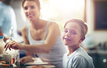 Boy, child and portrait in kitchen for breakfast or morning routine for healthy diet, vitamins and nutrition. Male kid, mother and happy in home with food for eating or relax, calm and wellbeing.