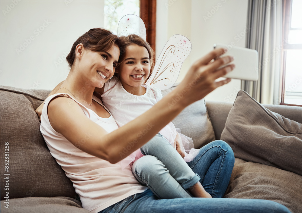 Wall mural Mom, girl and happy on selfie on sofa for memories, fun and care with support for child development. Family, people and smile in living room on couch for social media, bonding and home with butterfly