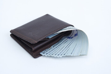 Leather wallet full of money on white background. One hundred dollar bills in cash