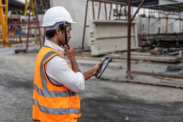 Obraz premium A mechanical engineer using software or application through electronic device or tablet or gadget to work in a construction site.