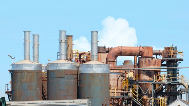 Industrial equipment in scrapyard recycling material delivered by dump trucks