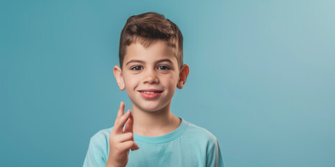A deaf austic boy looking at the camera and using sign language to say thank you