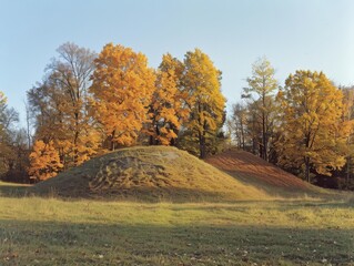 Fototapeta premium Medium shot of Photo of a hill with trees and grass, in the background is English countryside, golden hour, autumn season.