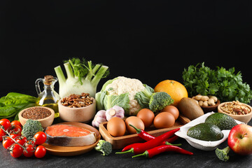 Many different healthy food on dark textured table against black background. Space for text