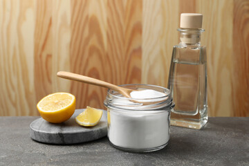Baking soda, vinegar and lemon on grey table