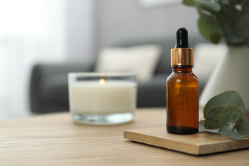 Aromatherapy. Bottle of essential oil and eucalyptus leaves on wooden table