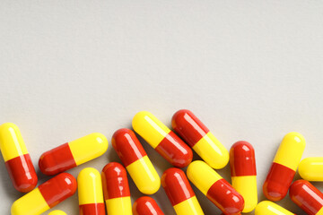Many antibiotic pills on grey background, top view and space for text. Medicinal treatment