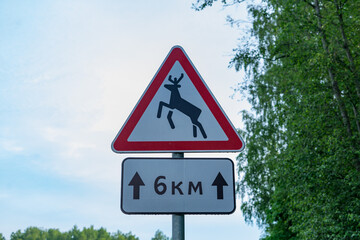 Warning road sign deer about the movement of wild animals