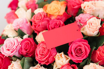 Bouquet of beautiful roses with blank card, closeup