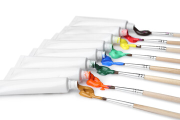 Fototapeta premium Tubes with colorful paints and brushes isolated on white