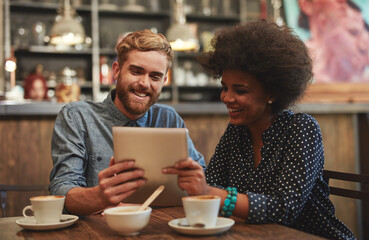 Couple, tablet and happy on date in coffee shop with social media streaming, bonding and online information. Interracial, people and smile in cafe with tech app for post update, discussion and relax