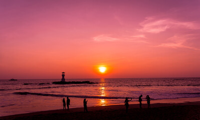 A lighthouse in the ocean during a beautiful sunset