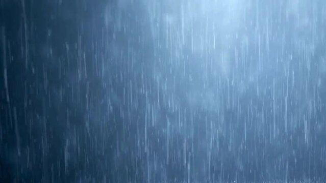 Background video of heavy rain falling, the water drops appear colorful with light