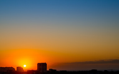 Fototapeta premium Sunrise over the Rooftops of a Seaside Town