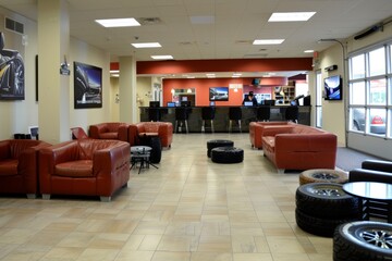 Tire Shop Customer Lounge Area With Red Seats and Tires for Automotive Service Design