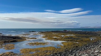 Rocky Shoreline With Volcano, Tidal Pools and Distant Mountains on a Sunny Day