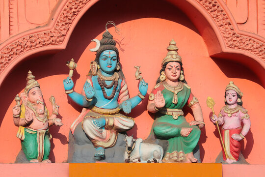 Shiva, Parvati, Ganesha and Subramanya - divine family on the wall of a Hindu temple in India.