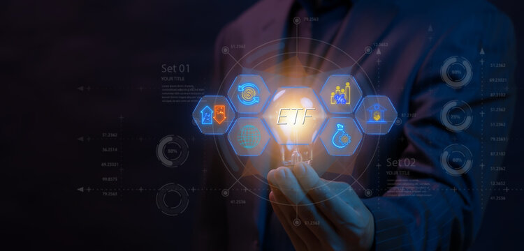 ETF, Exchange traded fund concept. Business stock market finance index fund. Businessman holding glowing lightbulb to show ETF icons on virtual screen.