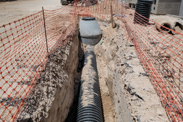 Escavação num canteiro de obras com tubulação exposta para infraestrutura de saneamento básico
