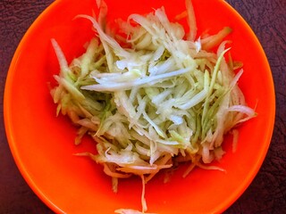 Sliced raw mango as an appetizer in the red bowl