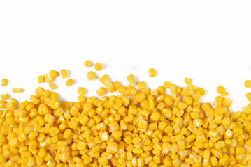 Close-up of yellow corn kernels scattered on a white background, showcasing fresh and vibrant food ingredients.