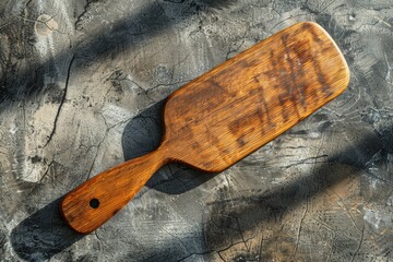 A wooden paddle resting on a metal surface, possibly in a workshop or storage area