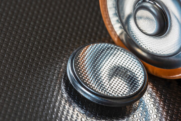 Flat lithium button cell and alkaline batteries close-up