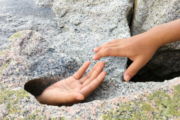 Hand request help from big stone hole.