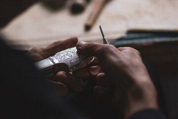 Selective focus. Hands of a dagger maker at work, close-up.