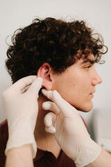 Otoplasty for changing the shape, position or size of the ears. Surgeon doctor examines ear of male...