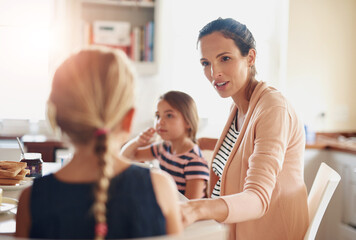 Woman, children and talking at breakfast in kitchen for bonding, love and care with healthy nutrition in morning. Mother, girl and happy family with conversation, support and eating lunch at house