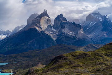 Cerro Paine Grande and Mont Almirante Nieto during cloudy but sunny weather with rolling green hills in the foreground