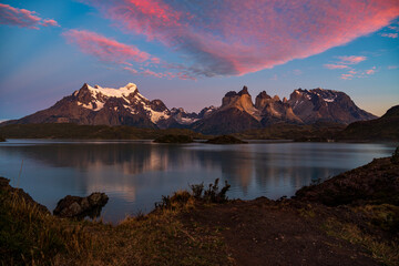 Cerro Paine Grande, Cerro Paine Grande, and Mont Almirante Nieto during a pink sunrise reflected in Lago Pehoe with fleecy clouds