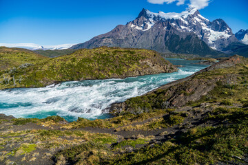 A fast flowing white water turquoise river in front of the Cerro Paine Grande
