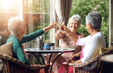 Senior woman, cheers and friends in restaurant for wine, vacation and retirement together with...