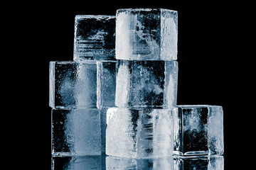 A group of three ice cubes, isolated on a black background.