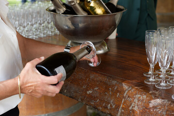 Champagne servi dans une flute, mains qui servent du champagne, service
