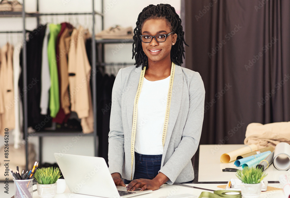 Poster african american woman is standing in front of a laptop computer, appearing focused as she interacts