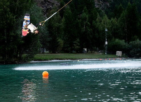 Wakeboarder executing a mid-air trick over a serene lake