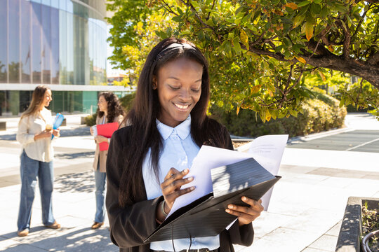 Professional woman reviewing documents outdoors with colleagues