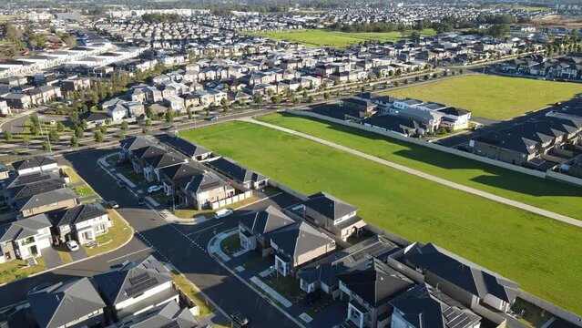 Aerial drone pullback reverse view of The Ponds in the North West of Sydney, NSW Australia on a sunny morning in June 2024 showing the densely packed homes and housing density