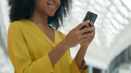 African American woman user mobile phone smartphone cellphone telephone technology texting online internet chatting girl smiling female shopping mall order browsing web virtual connect digital gadget