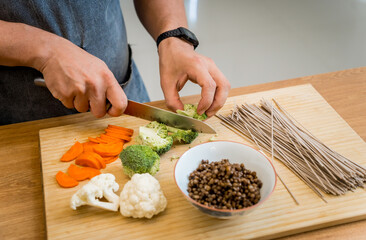 Chef at the kitchen preparing japanese buckwheat pasta with lentils