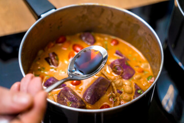Chef at the kitchen preparing massaman curry with sweet potato and many spices