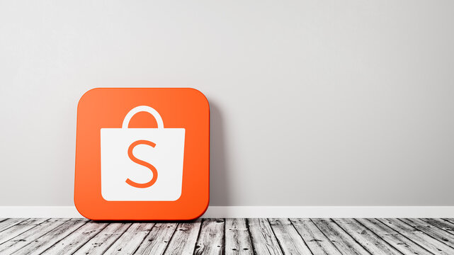 Shopee App Icon on Wooden Floor Against Wall