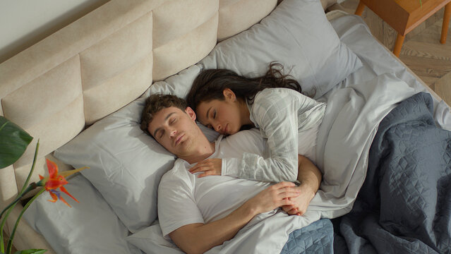 Couple love man woman sleep on bed bedroom home cosy wake up together happiness weekend rest daydream napping soft mattress warm apartment tenderness sweetheart intimacy cuddle harmony marriage warmth