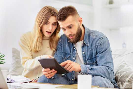 A man and woman are engaged, looking at something together on a tablet device.